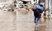 A man in Liège, Belgium, moves his belongings to safety. (© picture-alliance/Dursun Aydemir)
