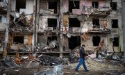 A resident in front of a destroyed building in Kyiv on February 25, 2022. (© picture alliance / ASSOCIATED PRESS / Emilio Morenatti)