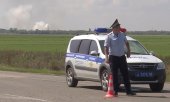 A police officer blocks the access road to the exploding ammunition depot in Maiskoje. (© picture alliance/ASSOCIATED PRESS/Uncredited)