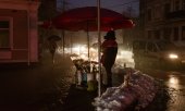 70 percent of the households in Kyiv have been deprived of electricity. Here a woman sells flowers, lit up by the headlights of a car. (© picture alliance/AA/Andre Luis Alves)